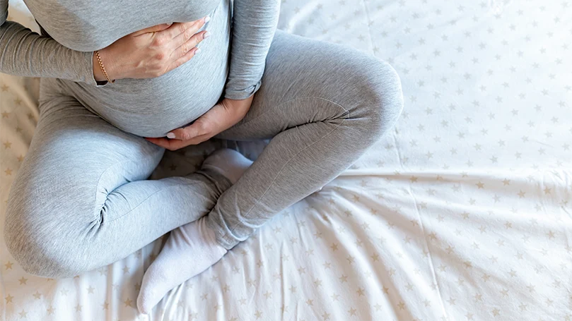 en-gravid-kvinna-håller-ihennes-mage