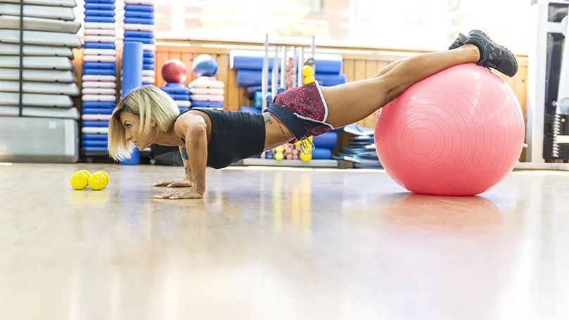 En bild av en kvinna som gör en Decline armhävning på en yogaboll