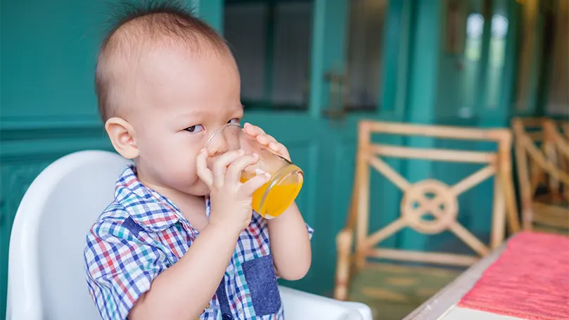 En bild av en 18 månader gammal bebis som dricker juice.