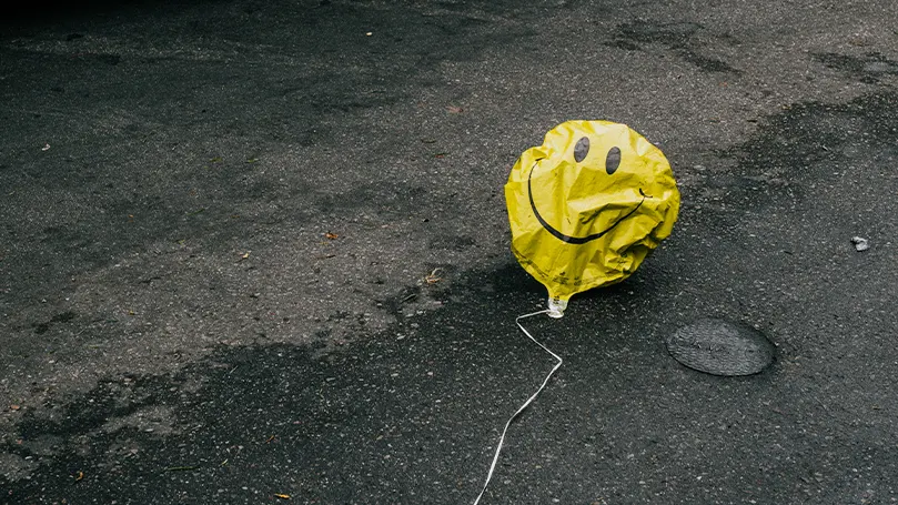 En bild av en urblåst ballong med en smiley på