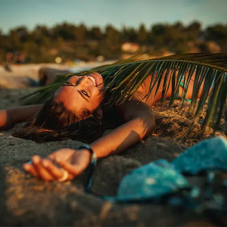 En ung kvinna som sover på stranden på kvällen