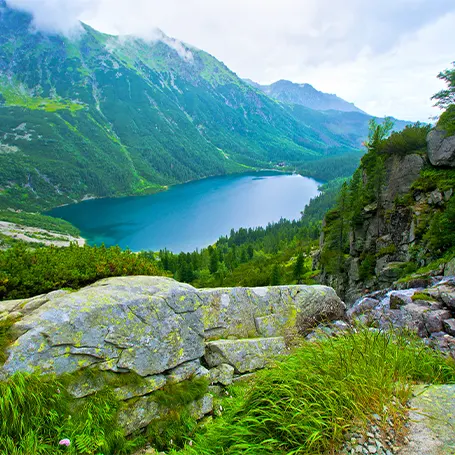 En bild av ett landskap med berg och en sjö i fjärran